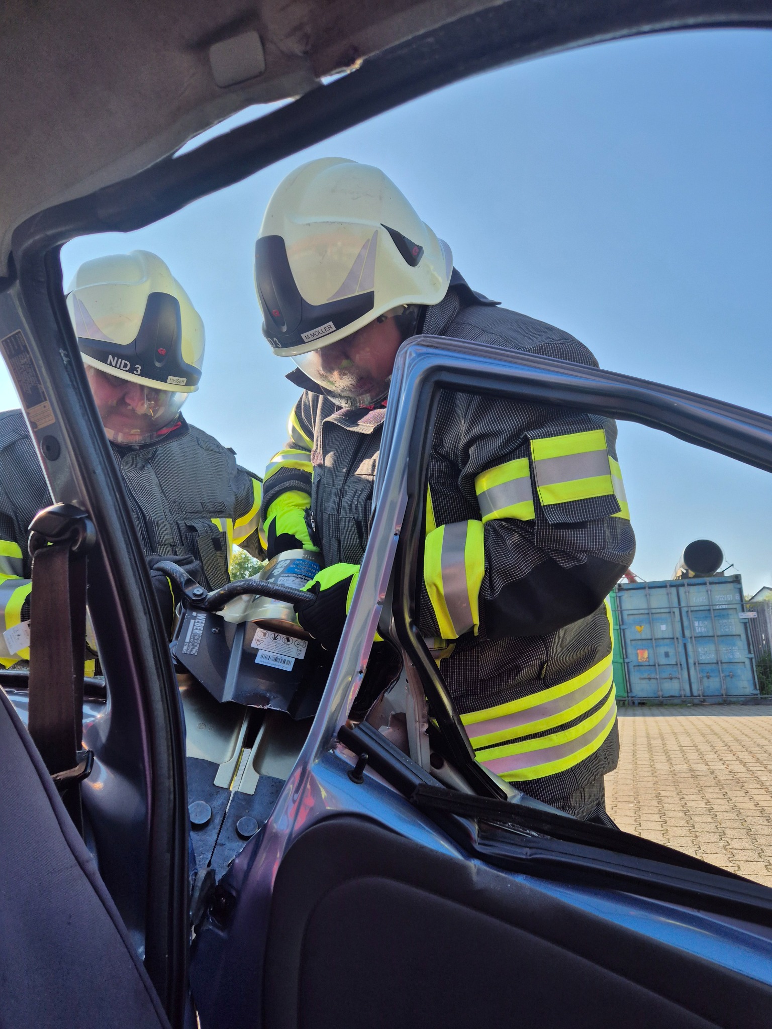 Feuerwehrkräfte arbeiten mit hydraulischem Rettungsgerät an einem Fahrzeug